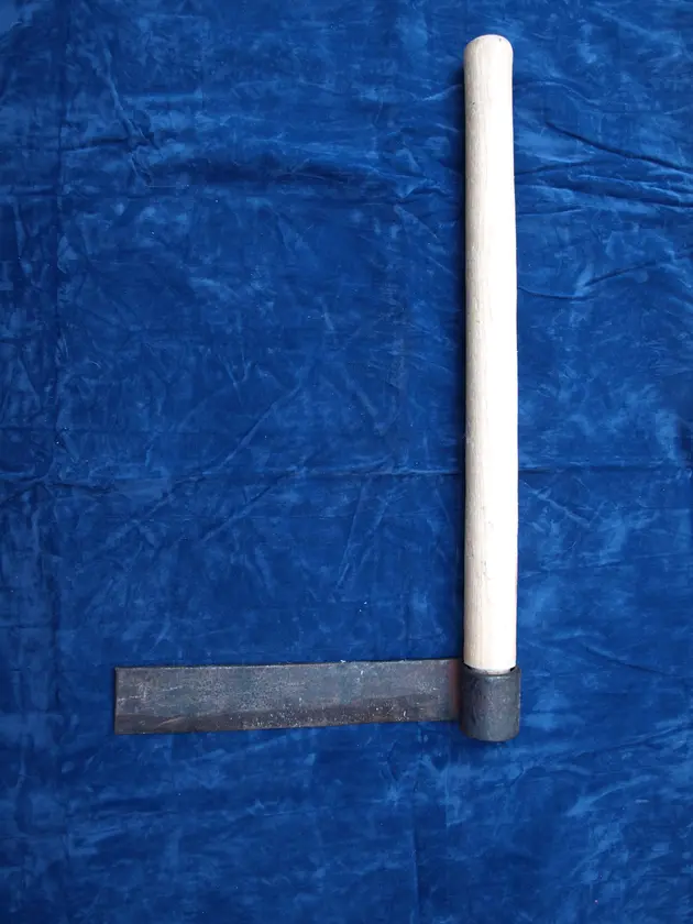 A froe: a flat blade set at right angles to a long wooden handle